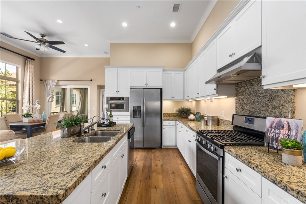 97 Mayfair Irvine, CA 92620 - Photo 13 of 42 a kitchen with stainless steel appliances granite countertop a sink a stove and a refrigerator
