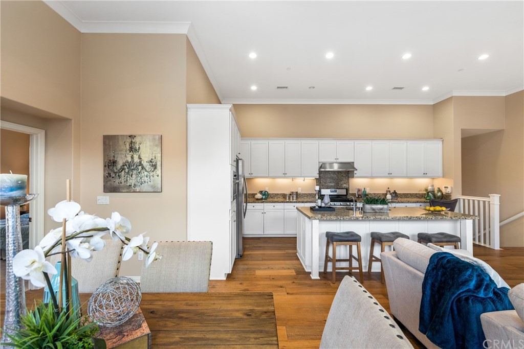 97 Mayfair Irvine, CA 92620 - Photo 17 of 42 a living room with stainless steel appliances furniture a rug and a kitchen view