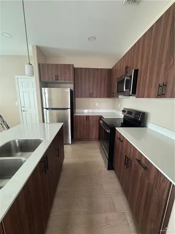 a kitchen with stainless steel appliances a sink dishwasher stove and refrigerator
