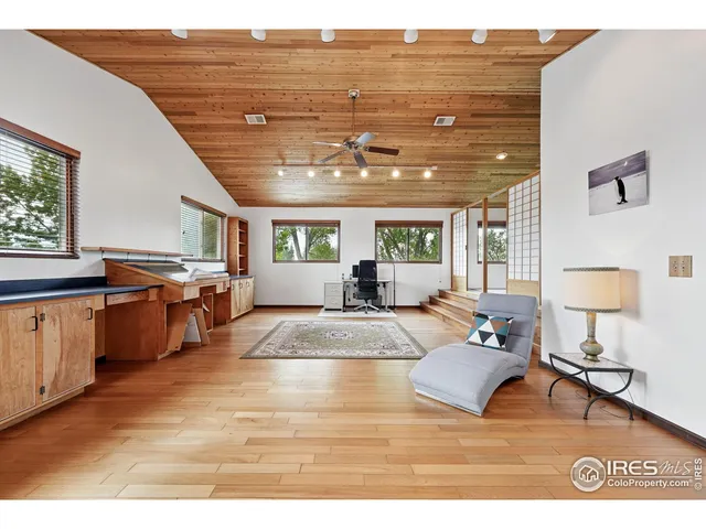 a view of a livingroom with furniture hardwood floor and windows