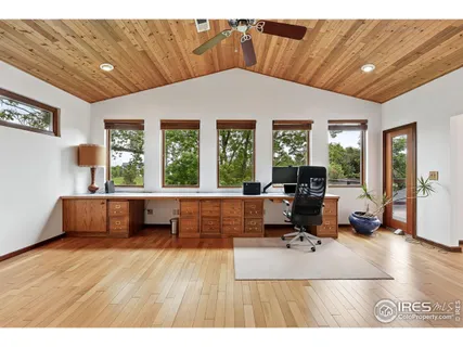 a living room with furniture a flat screen tv and floor to ceiling window