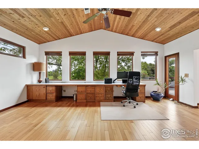a living room with furniture a flat screen tv and floor to ceiling window