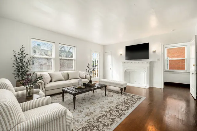 a living room with furniture a flat screen tv and a fireplace