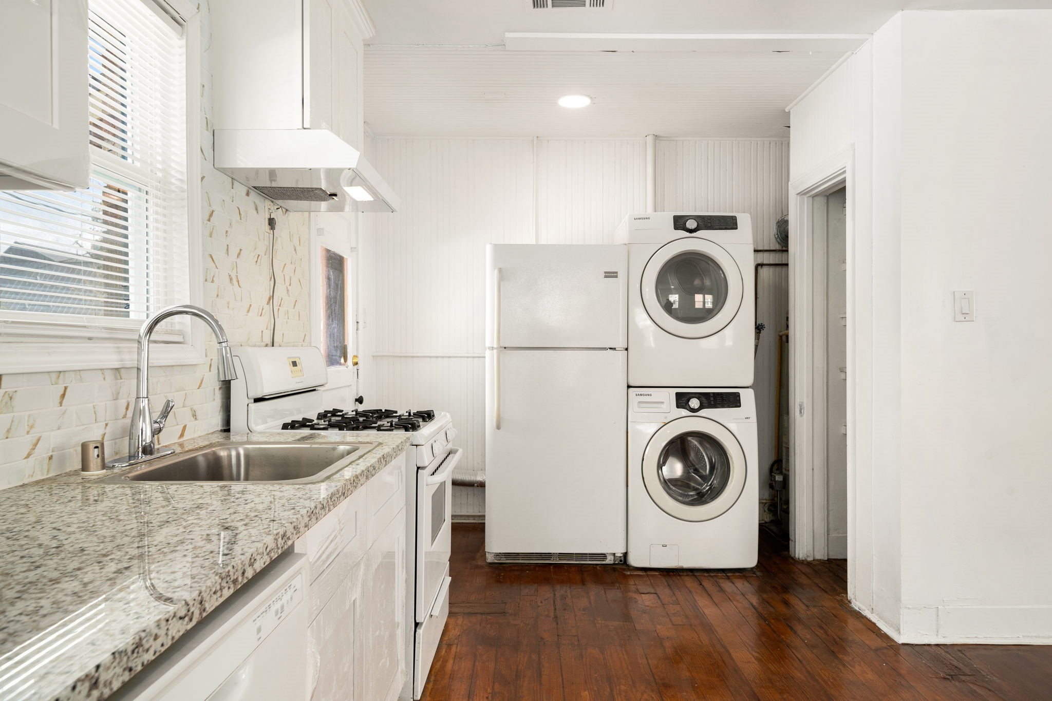 1202 Barkdull Street Houston, TX 77006 - Photo 27 of 48 a kitchen with a stove a sink and a washer dryer