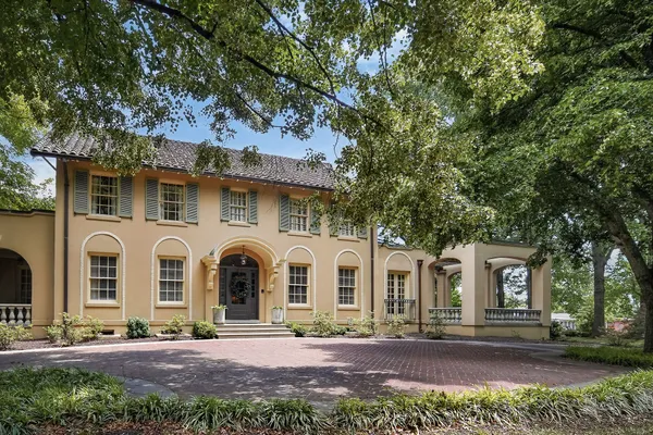 a view of a white house with a big yard and large tree