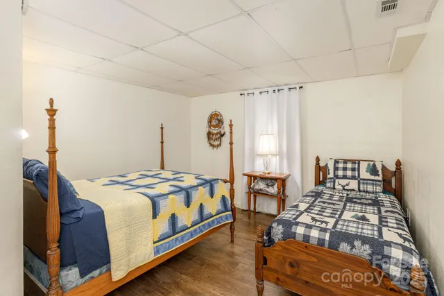 a bed sitting in a bedroom next to a window and a chandelier