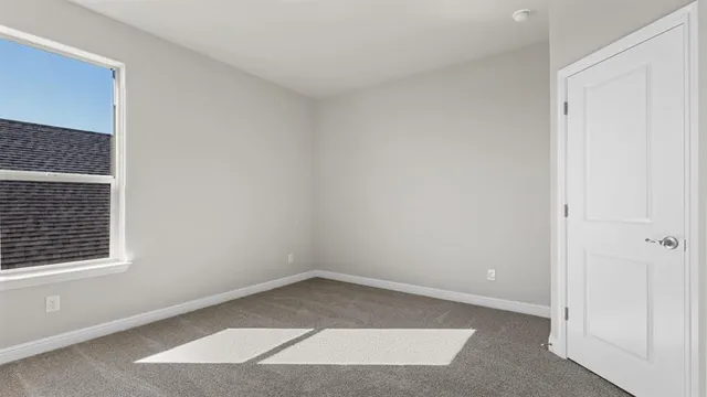 an empty room with a ceiling fan and a window