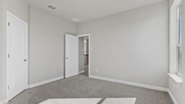 an empty room with closet and windows