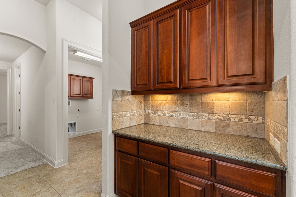 651 Shelf Rock Road Driftwood, TX 78619 - Photo 13 of 38 a kitchen with granite countertop wooden cabinets a sink and dishwasher