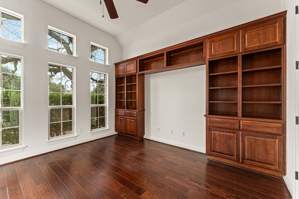 651 Shelf Rock Road Driftwood, TX 78619 - Photo 17 of 38 a view of an empty room with a window and wooden floor