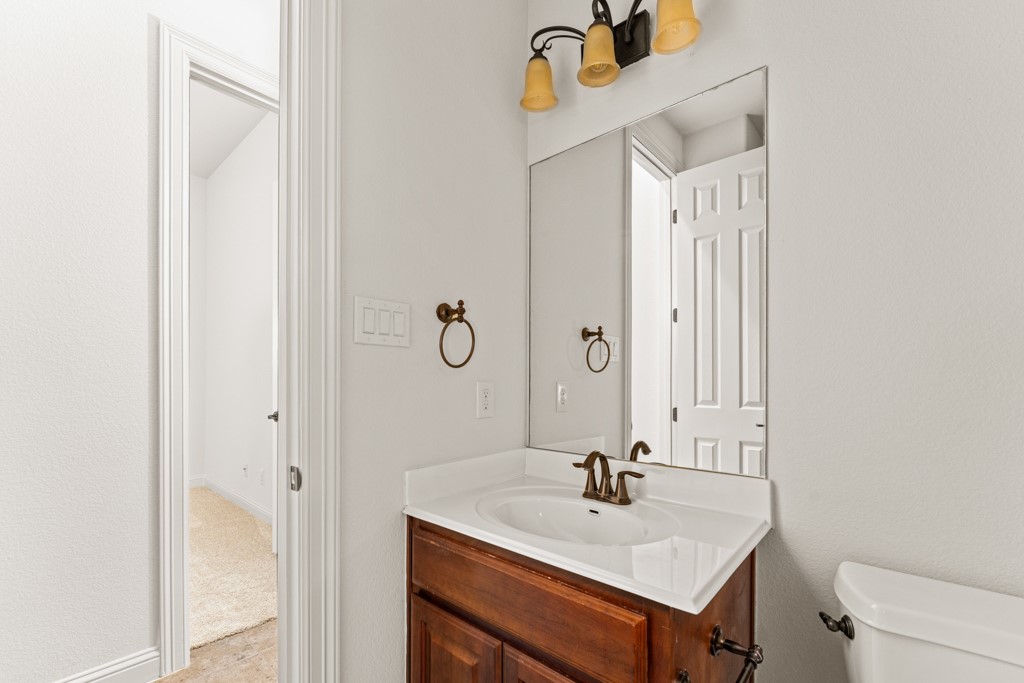 651 Shelf Rock Road Driftwood, TX 78619 - Photo 20 of 38 a bathroom with a sink a toilet and a mirror