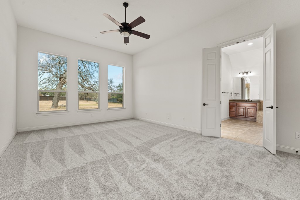 651 Shelf Rock Road Driftwood, TX 78619 - Photo 22 of 38 an empty room with windows and ceiling fan