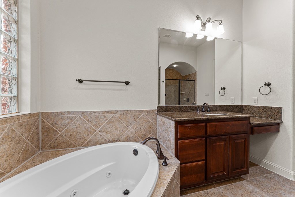 651 Shelf Rock Road Driftwood, TX 78619 - Photo 24 of 38 a bathroom with a bathtub sink and mirror