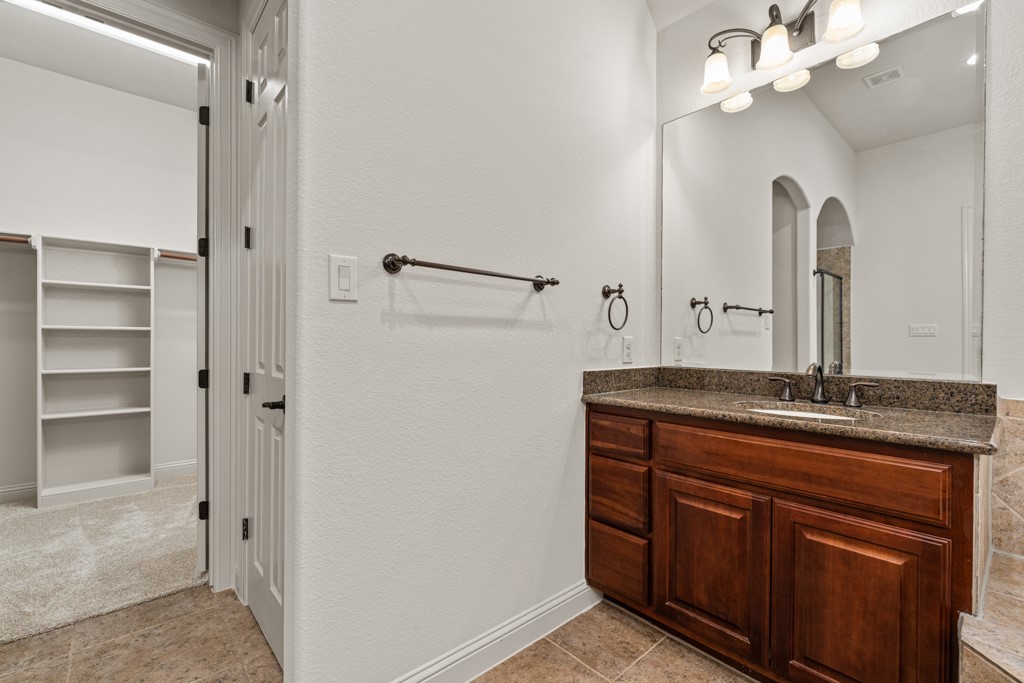 651 Shelf Rock Road Driftwood, TX 78619 - Photo 25 of 38 a bathroom with a granite countertop sink a mirror and a shower