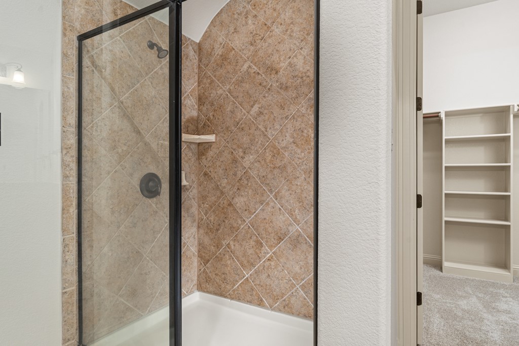 651 Shelf Rock Road Driftwood, TX 78619 - Photo 26 of 38 a bathroom with a glass shower door