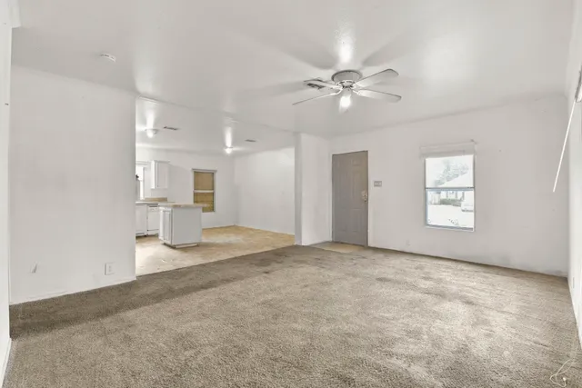 a view of empty room with a kitchen