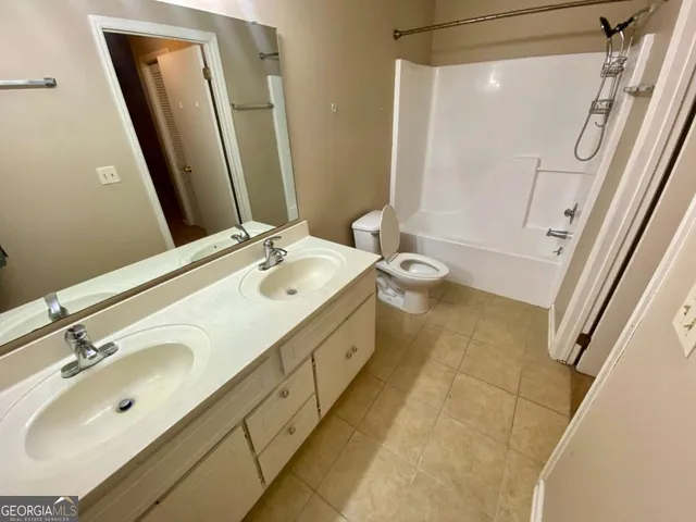 a spacious bathroom with a double vanity sink a mirror and a shower