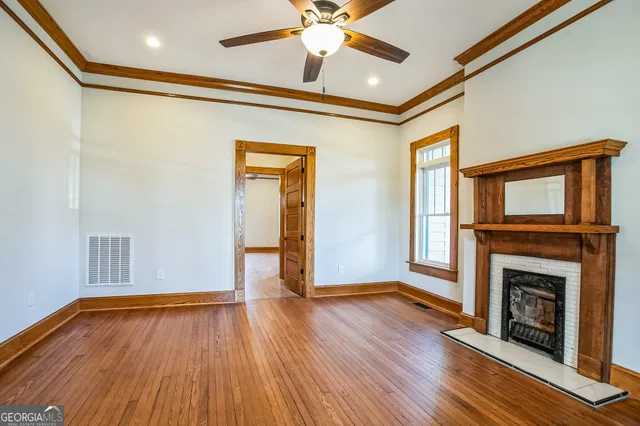 a view of empty room with a fireplace and wooden floor