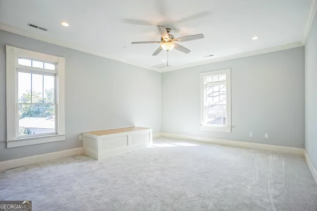 an empty room with windows and fan