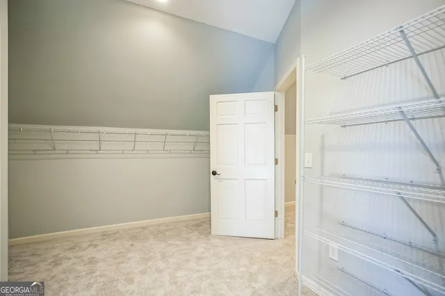 a view of walk in closet with empty racks
