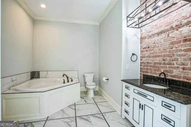 a bathroom with a granite countertop sink a toilet and bathtub
