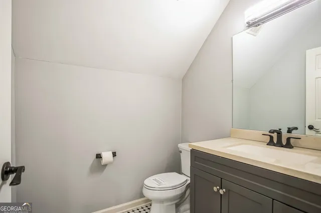 a bathroom with a granite countertop sink a toilet and a mirror