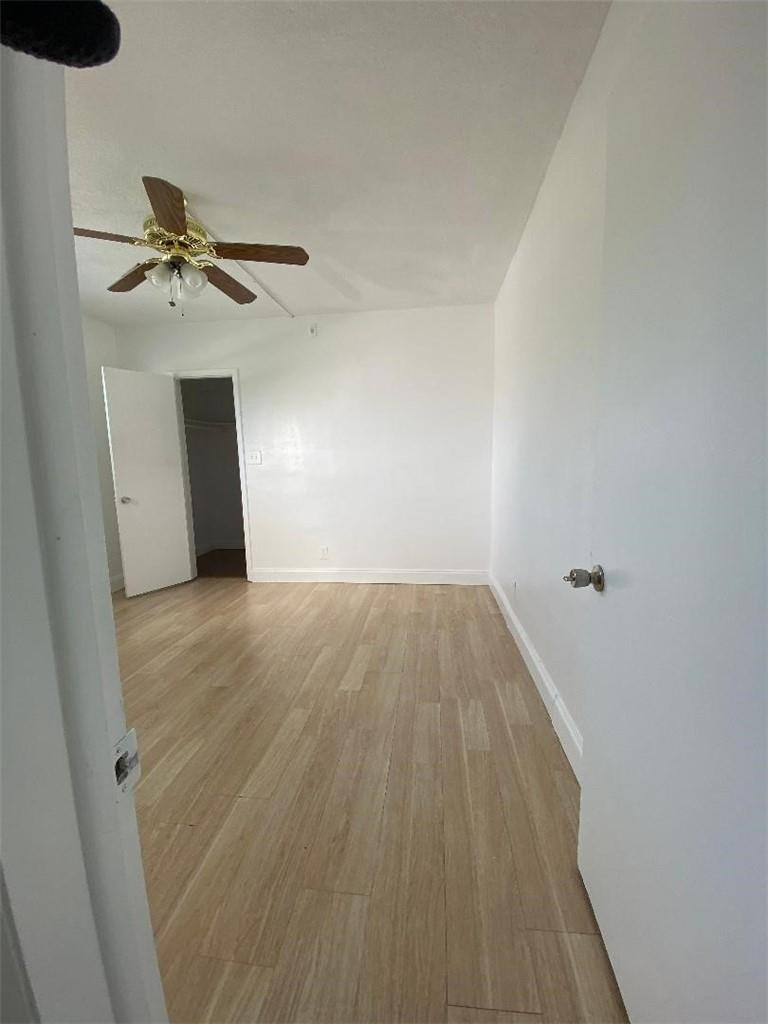 1855 Plunkett Street, Unit 101 Hollywood, FL 33020 - Photo 13 of 25 a view of a room with wooden floor and a ceiling fan