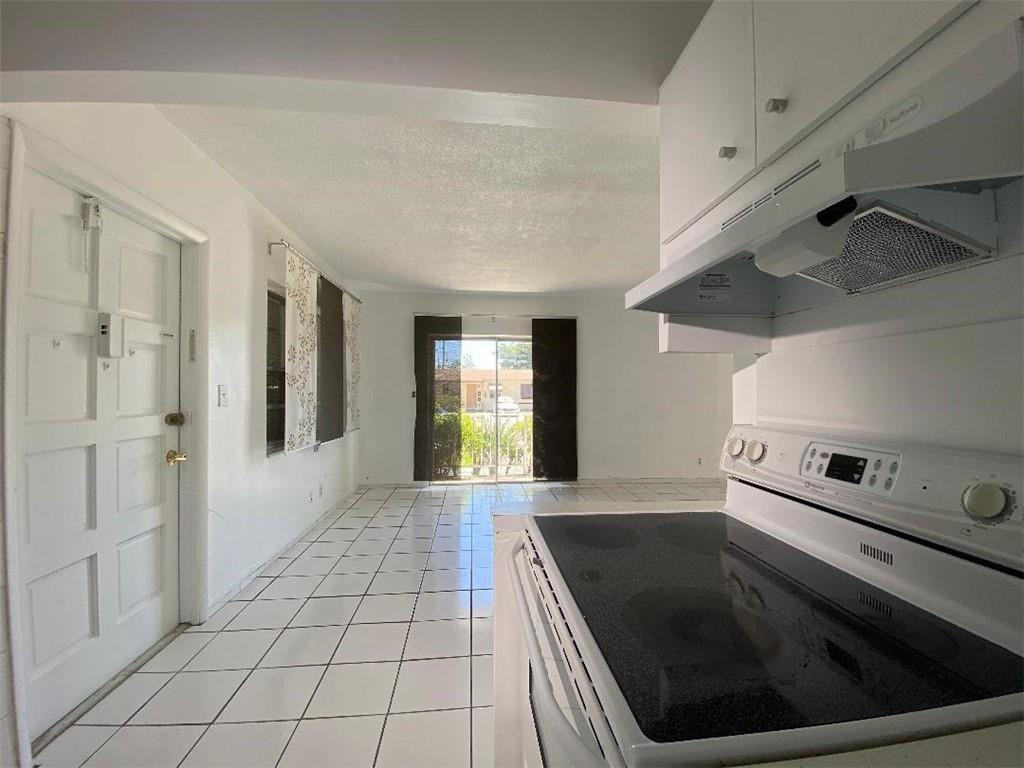 1855 Plunkett Street, Unit 101 Hollywood, FL 33020 - Photo 9 of 25 a kitchen with a stove and a refrigerator