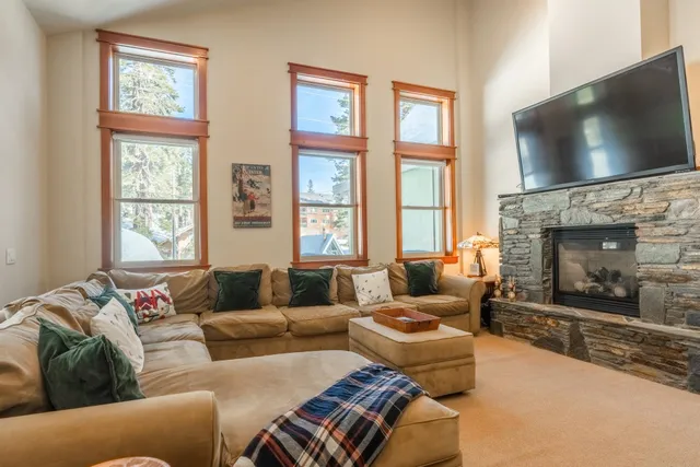 a living room with furniture a flat screen tv and a fireplace