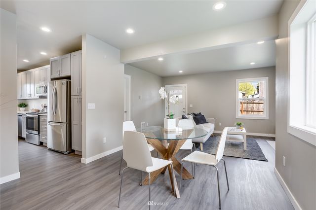 a view of a dining room with furniture a rug and wooden floor