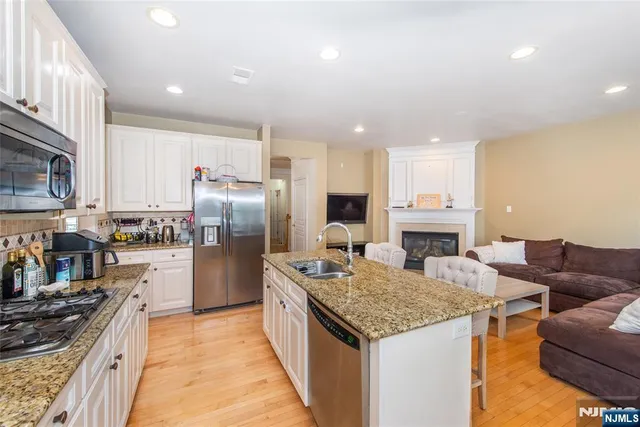a kitchen with kitchen island granite countertop a sink and refrigerator