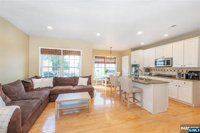 a living room with stainless steel appliances furniture cabinets and a kitchen counter top