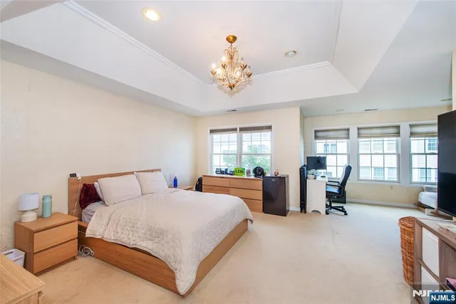 a spacious bedroom with a bed and a chandelier