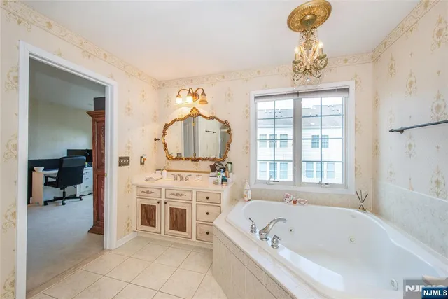 a bathroom with a tub sink and mirror