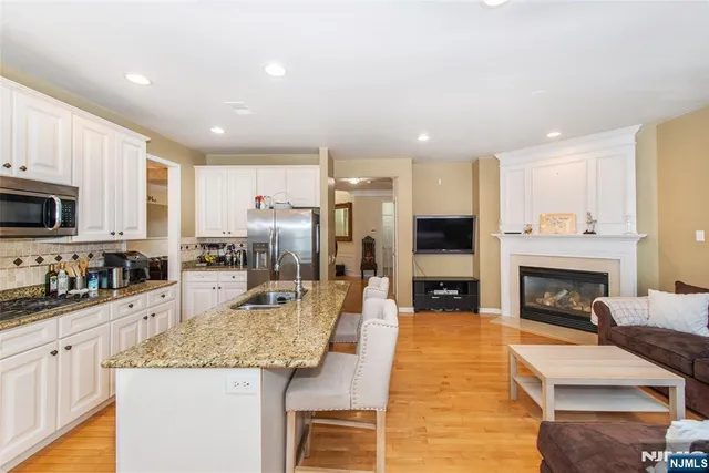 a kitchen with stainless steel appliances granite countertop a refrigerator a stove top oven a sink and dishwasher