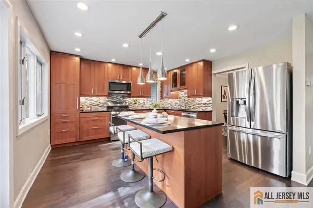 a kitchen with stainless steel appliances granite countertop a refrigerator and a stove top oven