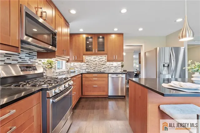 a kitchen with stainless steel appliances granite countertop a stove a sink and a microwave
