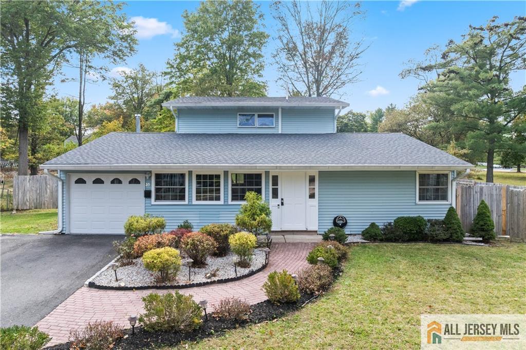 35 Emerald Road Kendall Park, NJ 08824 - Photo 3 of 37 a front view of a house with a yard and potted plants