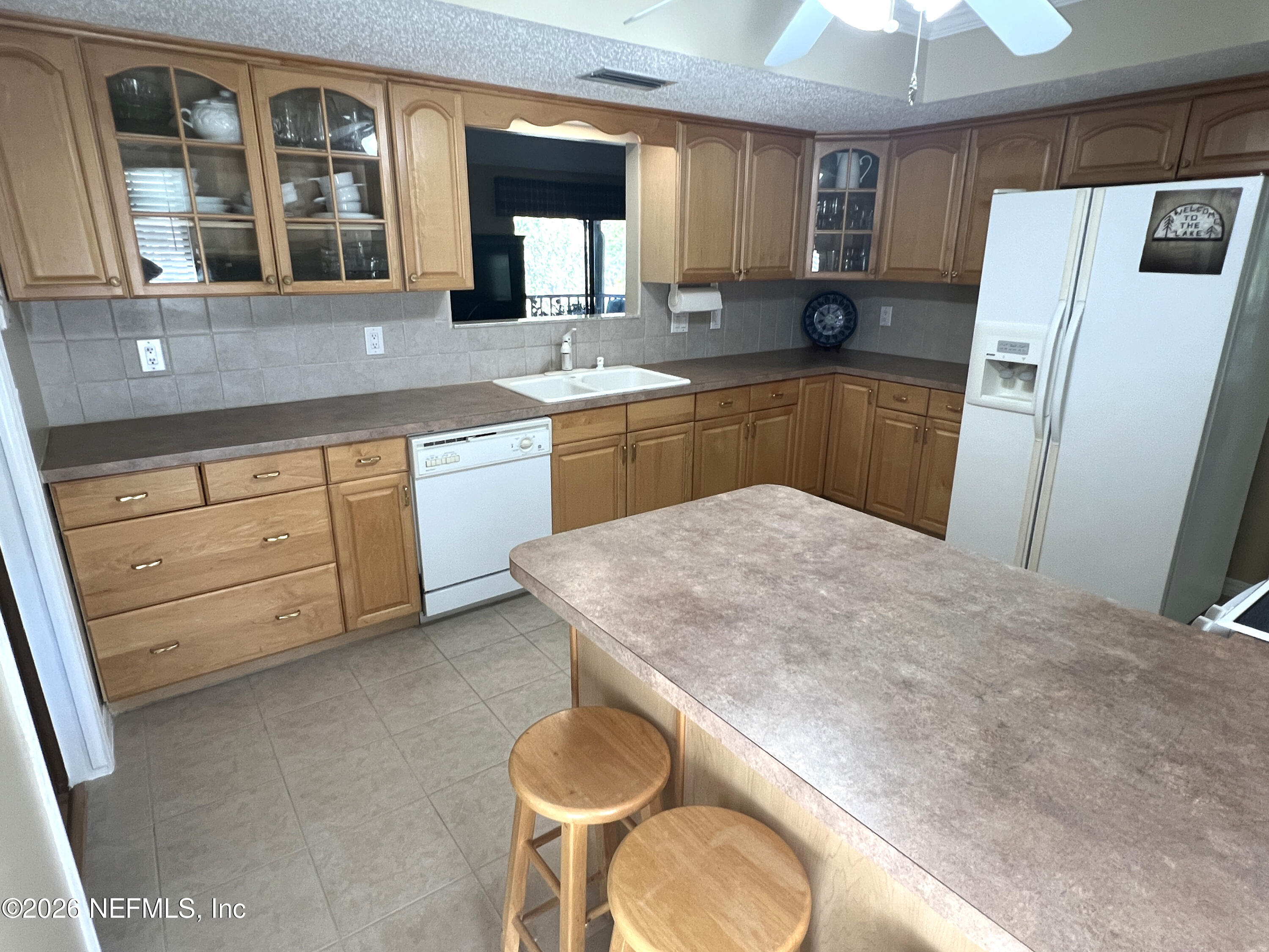 268 Wesley Road Green Cove Springs, FL 32043 - Photo 32 of 84 a kitchen with a refrigerator sink and cabinets