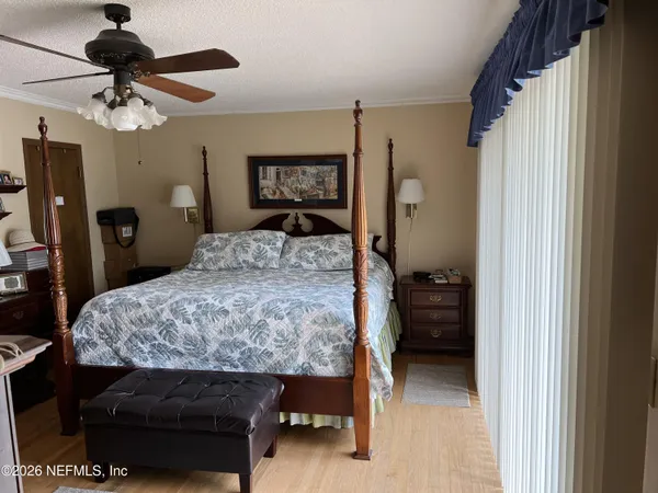 a bedroom with a bed and a large mirror next to a window