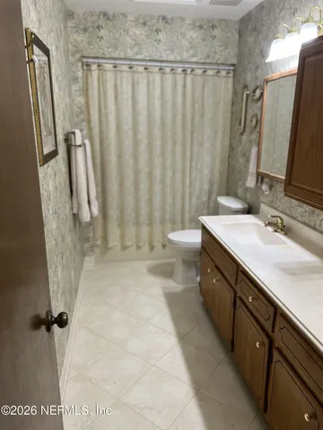 a bedroom with a bed and a large mirror next to a window