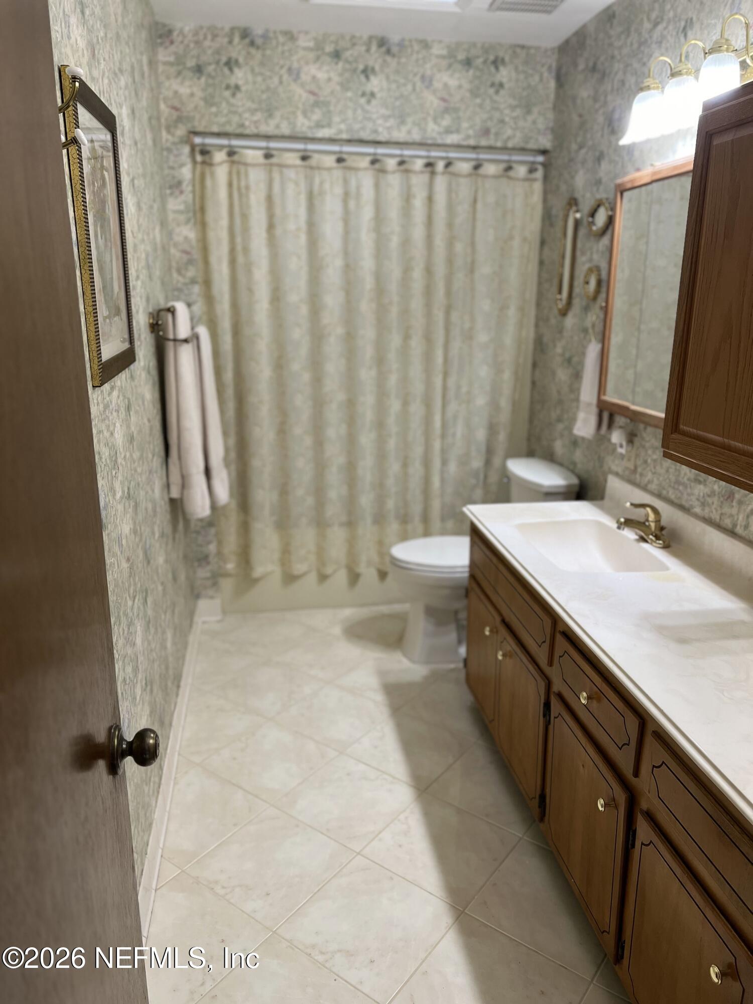 268 Wesley Road Green Cove Springs, FL 32043 - Photo 46 of 84 a bathroom with a sink a toilet a mirror and shower