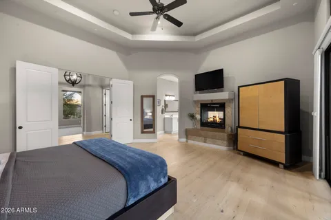 a spacious bedroom with a bed and a flat screen tv