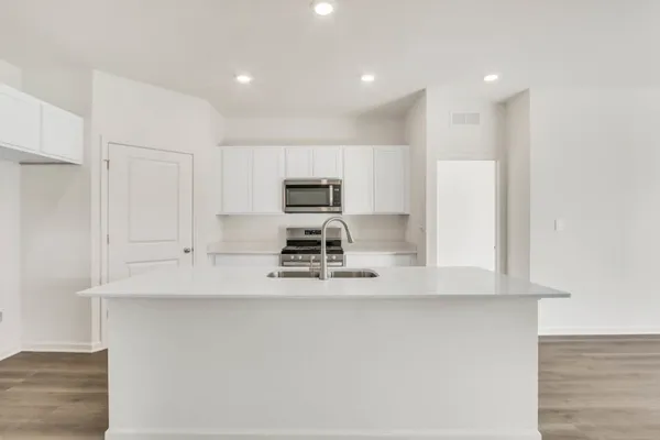 a kitchen with kitchen island white cabinets and stainless steel appliances