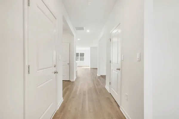 a view of a hallway with wooden floor