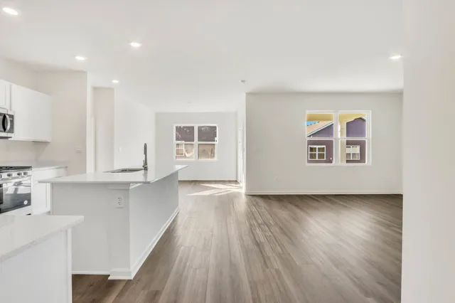 a view of a kitchen with wooden floor and a window
