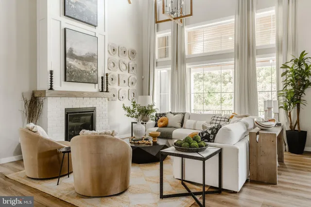 a living room with furniture a large window and a fireplace