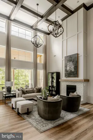 a living room with furniture a chandelier and a large window