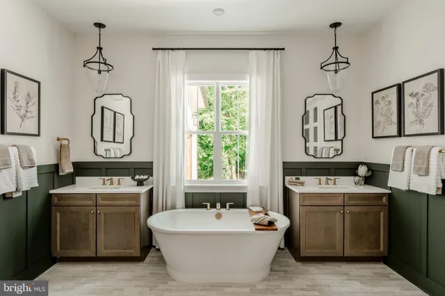 a bathroom with a sink vanity mirror bathtub and window