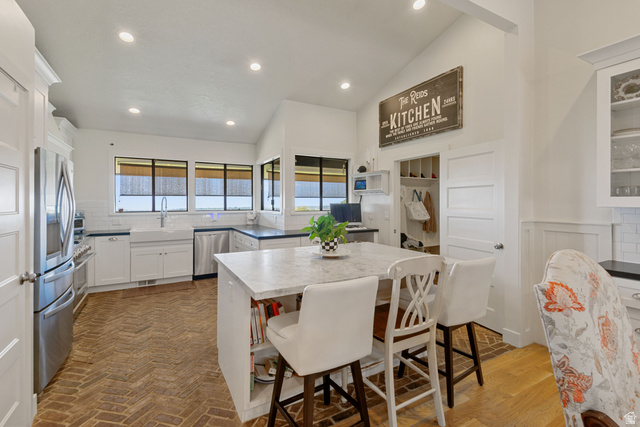 1900 North 100 East Provo, UT 84604 - Photo 12 of 49 Spacious kitchen featuring vaulted ceilings, a large center island with integrated shelving, stainless steel appliances, and a farmhouse sink